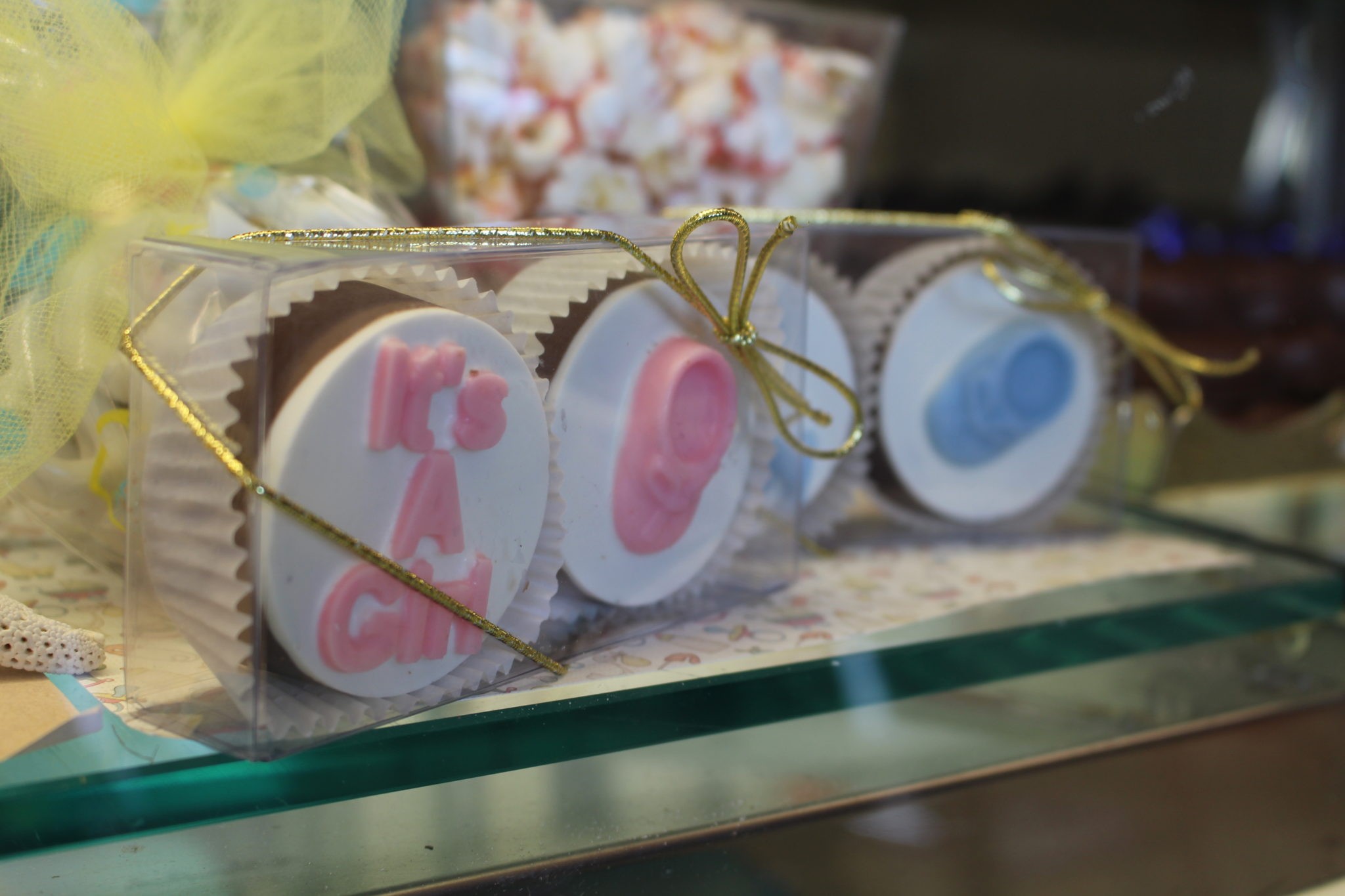 Chocolate covered Oreos decorated with pink and blue chocolate footprints.