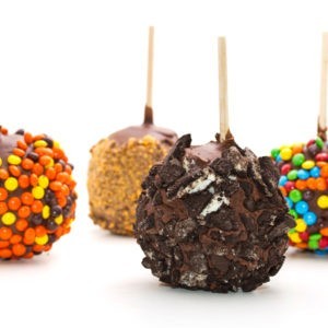 Fudge Covered Candy Apples with different toppings.