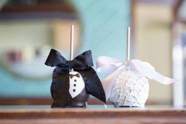 Two Groom and Bride chocolate covered apples dressed in a tux and dress with bows.