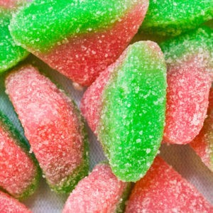 Close up of pink and green sour watermelon gummies.