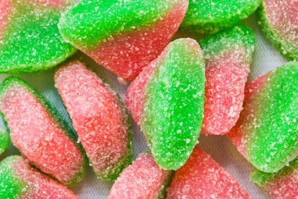 Close up of pink and green sour watermelon gummies.