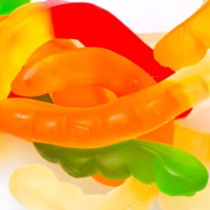 Close up shot of yellow, orange, red and green colored gummy worms.