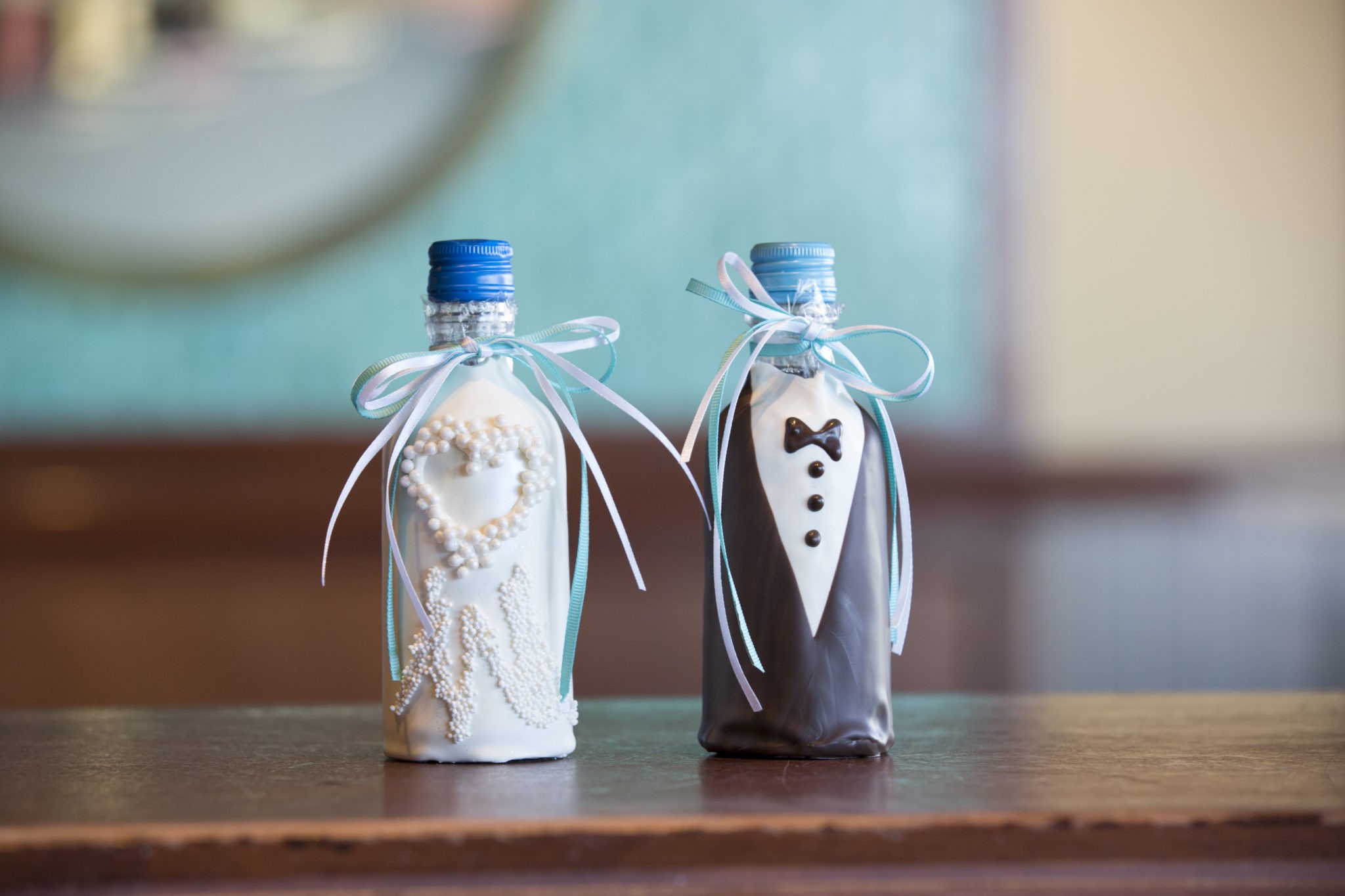 Two miniature bride and groom chocolate dipped wine bottles.