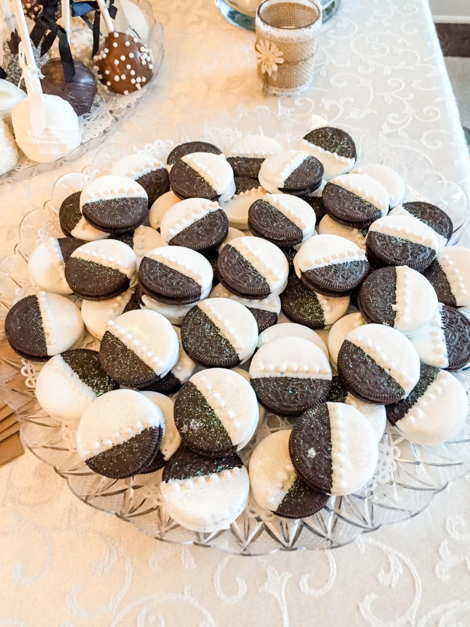 A platter of half dipped chocolate covered Oreos for a bridal shower.