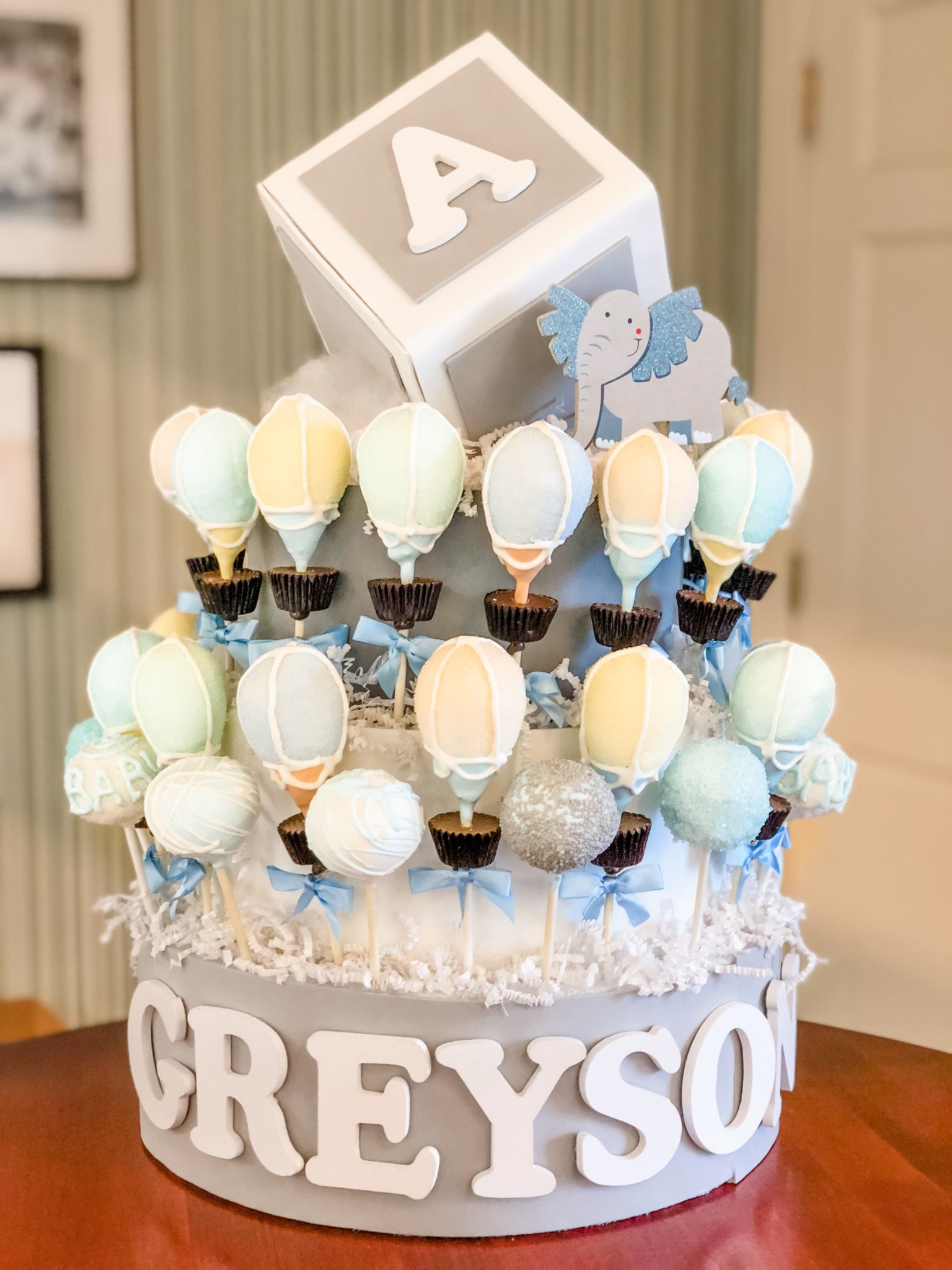 Custom cake pop display filled with baby shower themed cake pops.