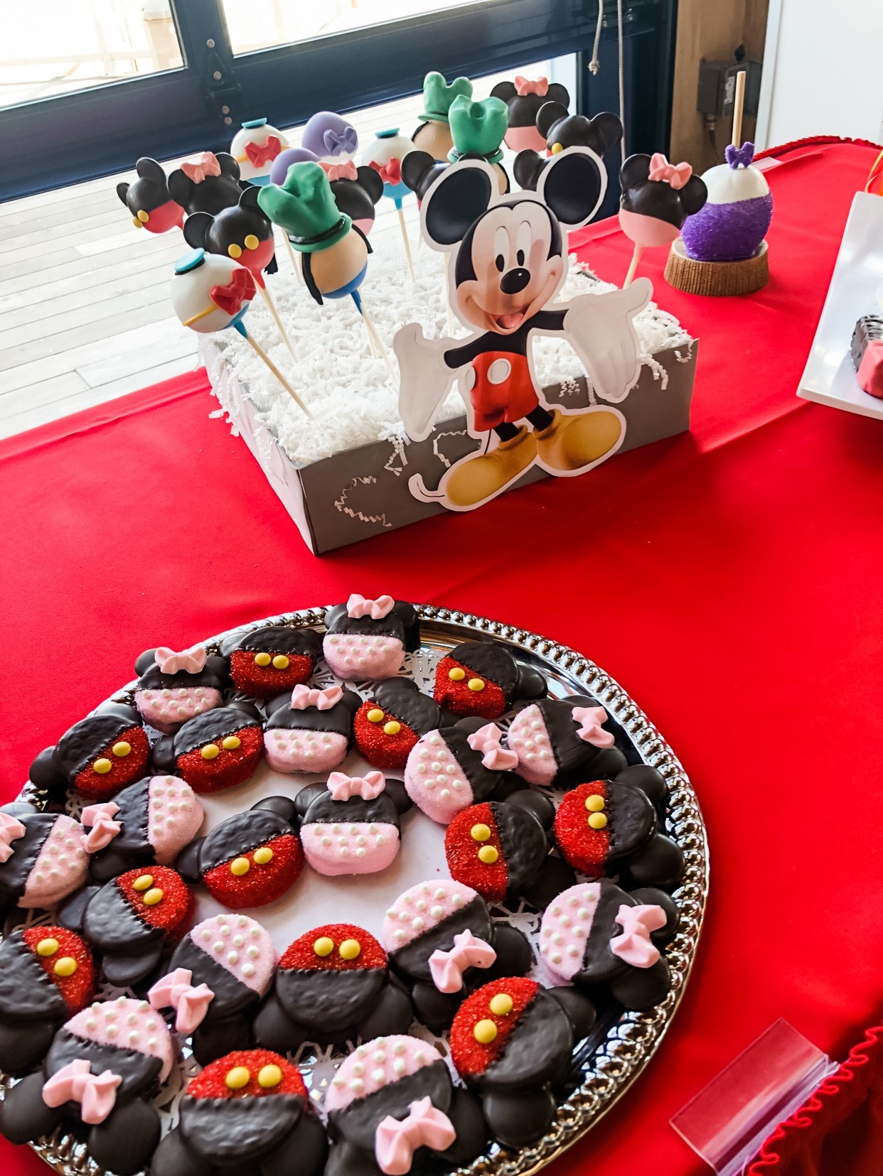 A dessert table featuring Mickey Clubhouse chocolate dipped Oreos and Lollies.