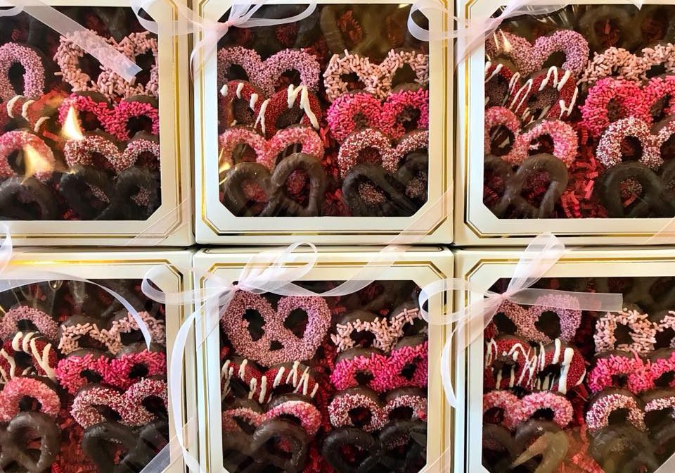 A bunch of Valetine's day chocolate covered pretzels in a gift box.