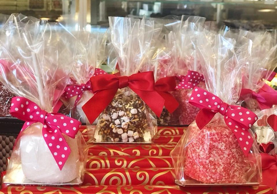 A bunch of chocolate dipped marshmallows decorated for Valentine's Day.