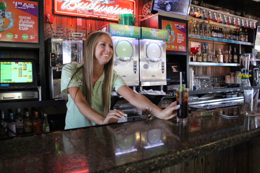 Picture of a young girl pouring a drink behind the Bar at Jenkinson's Boardwalk.
