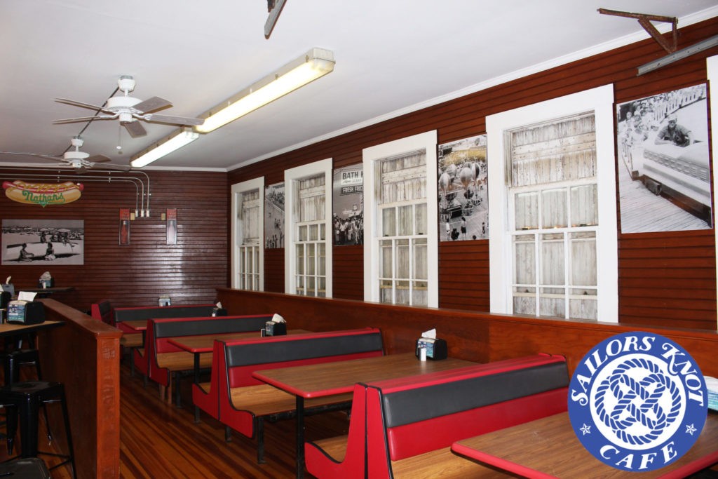 A picture of the interior of the Sailor's Knot Cafe showing the wooden booths next to the windows.