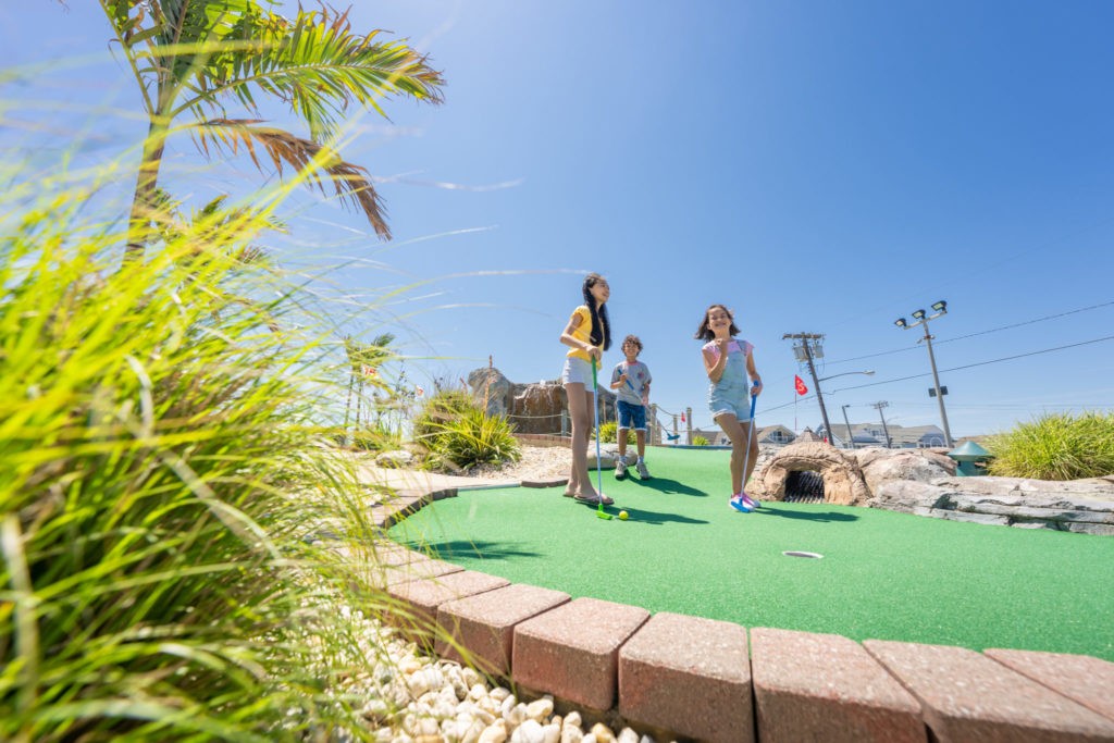 Two girls and a boy enjoy a round of golf at Lighthouse Point at Jenkinson's Boardwalk