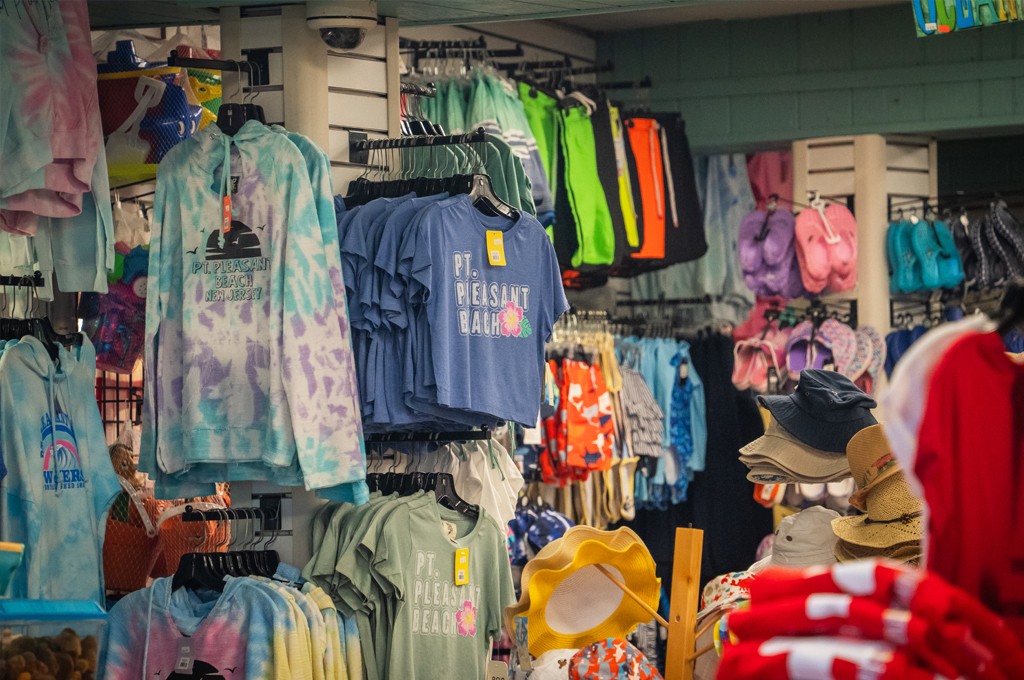 Assorted vibrant shirts and hats showcased in a store.