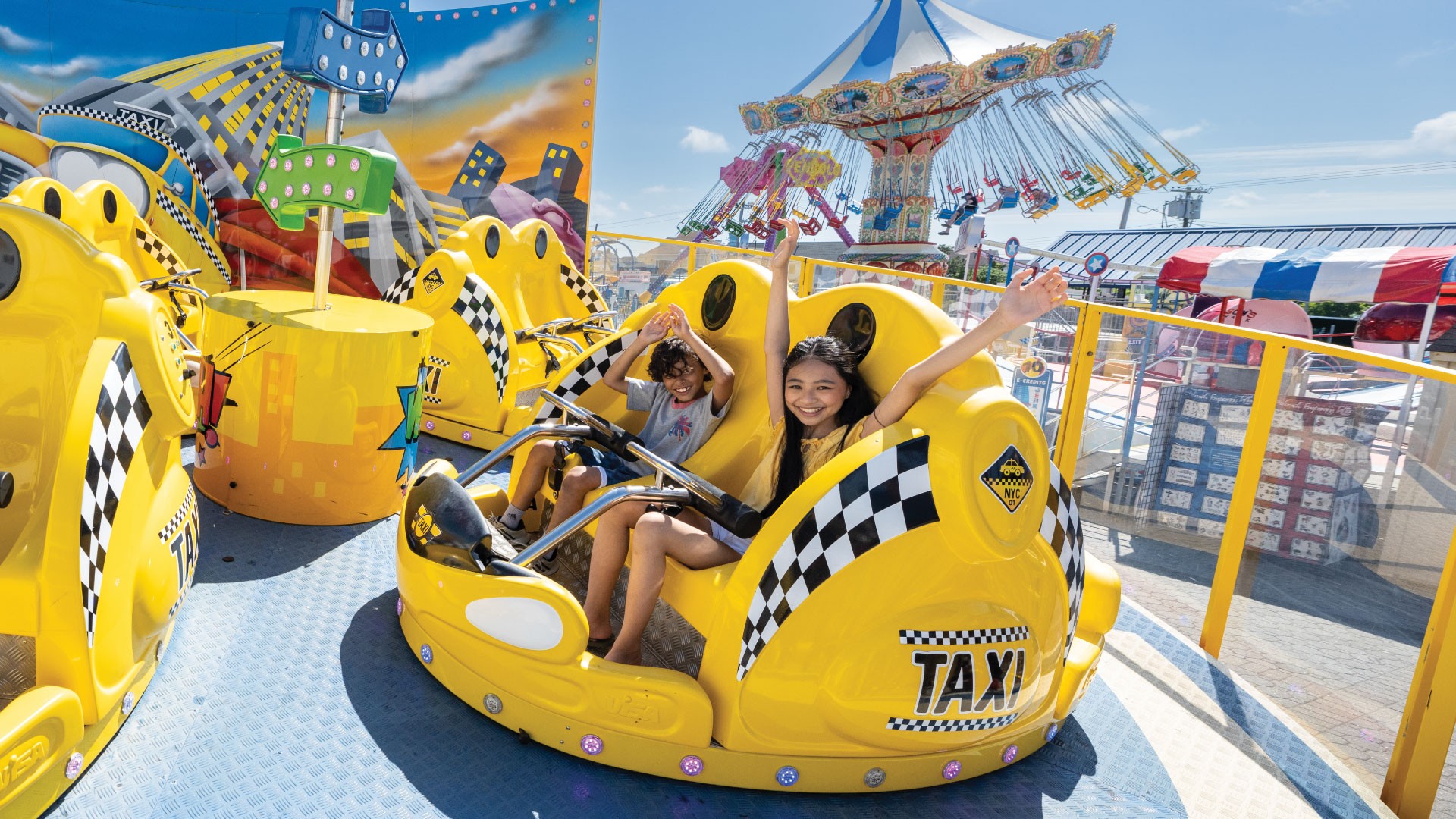 A family enjoying a thrilling ride in a yellow taxi at an amusement park, creating lasting memories.