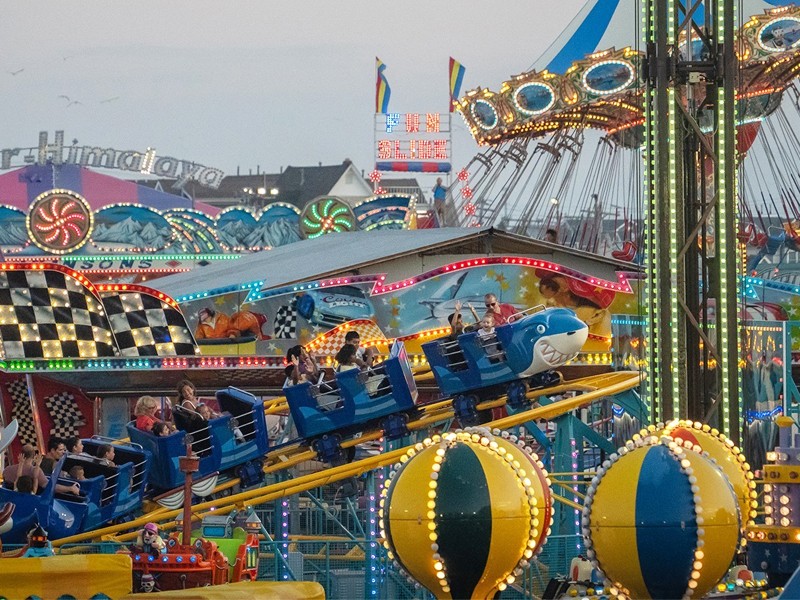 Families enjoying colorful rides at Jenkinson’s Amusement Park at night