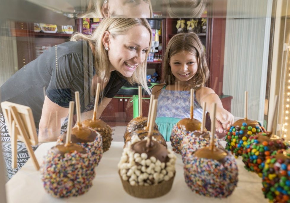 A mother and daughter looking at the candy apple in Jenkinson's Boardwalk Sweets Shop.