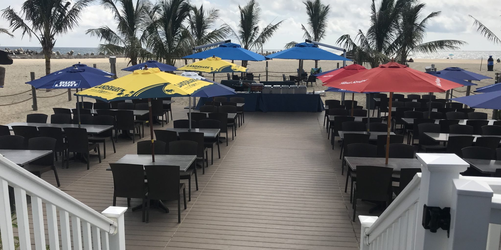 Tables and food set up on an outside deck looking at the ocean.