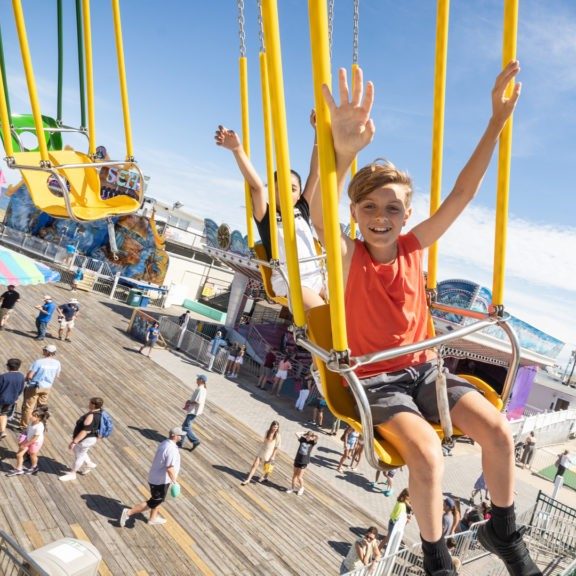 Riders enjoy Wave Swinger ride at Jenkinson's Boardwalk. Visitors pass through boardwalk