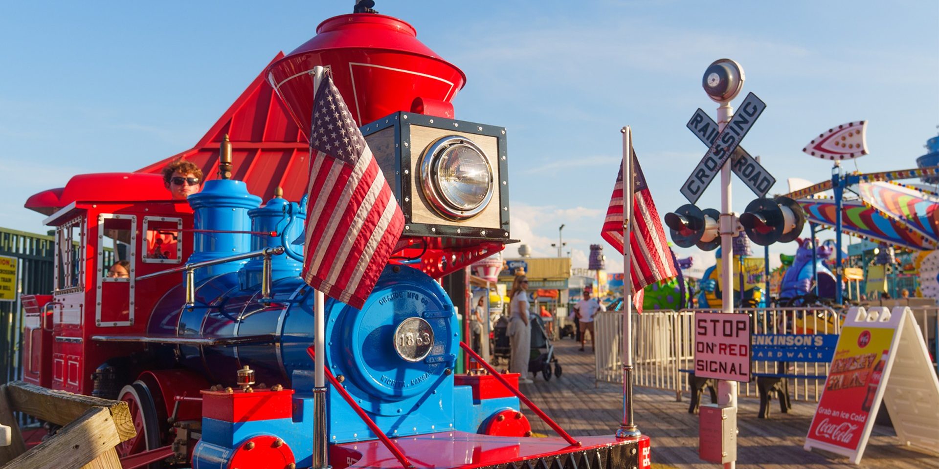 Red and blue train ride on Jenkinson’s Boardwalk with American flags