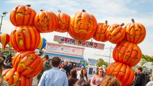 Guests walking under a festive pumpkin arch at Jenkinson’s Boardwalk during Boo at the Boardwalk 2025.